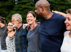 a diverse group of adults arm in arm